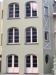 a facade of a building with white doors at Hotel Duinekeuntje in Ostend