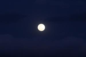 una luna llena en un cielo oscuro con nubes en Villa Rural San Miguel de la Loma en Tafí del Valle