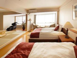 Rúm í herbergi á Atami Onsen Hotel Yume Iroha