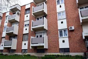 an apartment building with solar panels on the side at Weninger Studio Apartman in Kiskunhalas