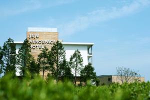 a building with a sign on the side of it at Jeju Aerospace Hotel in Seogwipo