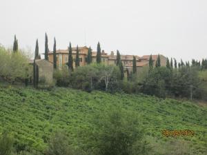 a large building in a field with trees and bushes at Tenuta Il Tresto in Poggibonsi