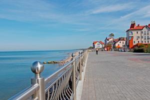 una passerella vicino all'oceano con case e una città di Princess Elisa Hotel a Zelenogradsk