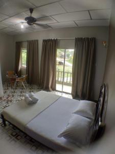ein großes Bett in einem Schlafzimmer mit Fenster in der Unterkunft Hana Guesthouse in Kuala Tahan