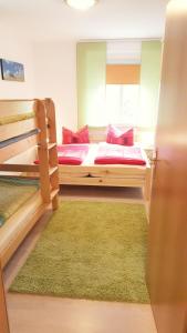 a bedroom with two bunk beds and a green rug at Spitzers Ferienwohnungen in Kurort Oberwiesenthal