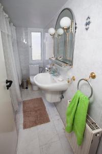 a white bathroom with a sink and a mirror at Despoina Town House in Limassol