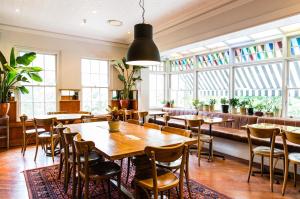 a restaurant with wooden tables and chairs and windows at Bridgeview Hotel Willoughby in Sydney