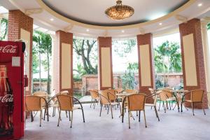 a restaurant with tables and chairs and a coke machine at Spring Garden Villa in Hue