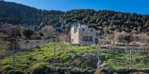 奧馬洛斯的住宿－Omalos Gianni's House，山丘上一座古老的石屋,设有围栏