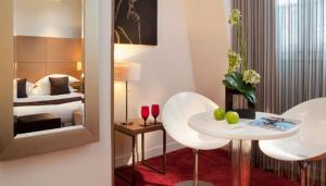 a hotel room with a bed and a table and chairs at Villathena in Paris