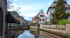 a river in a town with houses and a canal at Ferienhaus Pfistermühle in Wissembourg