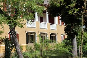 a building with a balcony on the side of it at Maison Poche in Caupenne-dʼArmagnac