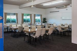 a room with tables and chairs in a classroom at Bentleigh Motor Inn in Coffs Harbour