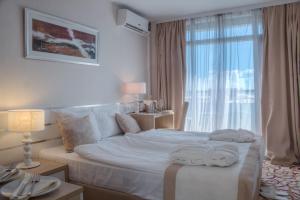 a white bedroom with a large bed with towels on it at Platinum Hotel & Casino in Sunny Beach +21 photos