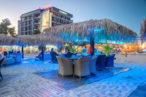 陽光海灘的住宿－鉑金賭場酒店，海滩上的餐厅,配有椅子和遮阳伞