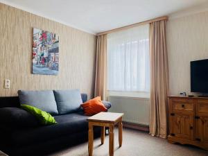 een woonkamer met een blauwe bank en een televisie bij Ferienwohnung Erfurt in Erfurt