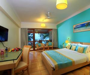 Habitación de hotel con cama, mesa y sillas en Uday Samudra Leisure Beach Hotel & Spa, en Kovalam