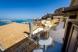a balcony with a table and chairs on a building at N'amuri Residence in Castellammare del Golfo