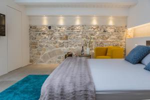 シラクーサにあるResidenza Nereoの石壁のベッドルーム1室(ベッド1台付)