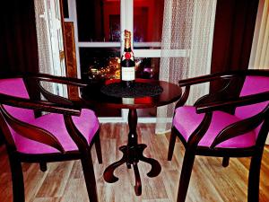 チェルニーヒウにあるApartLux 2のワイン1本(椅子2脚付きのテーブルに座る)
