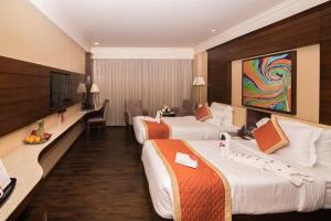 齋浦爾的住宿－沙昆度假村酒店，酒店客房设有两张床和一台平面电视。