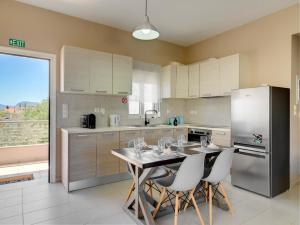 a kitchen with a table with chairs and a refrigerator at Pearl kokkonaki in Kokóni