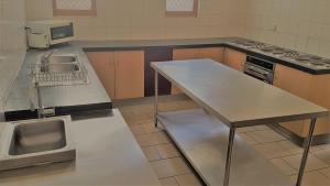 a kitchen with a sink and a table in it at myOZexp Palmerston Lodge in Perth
