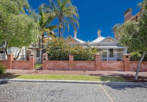 una cerca de ladrillo frente a una casa en myOZexp Palmerston Lodge en Perth