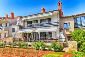 una gran casa blanca con balcón en Apartments Petra 628, en Fažana