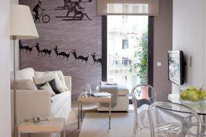 a living room with a white couch and camel painting on the wall at Eric Vökel Boutique Apartments - Sagrada Familia Suites in Barcelona