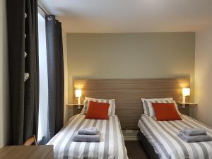 two beds sitting next to each other in a room at Causeway Bay Guesthouse Portrush in Portrush