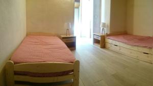 ein Schlafzimmer mit 2 Betten und einen Flur mit einem Fenster in der Unterkunft Les Olympiades in Bourg-Saint-Maurice