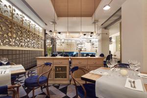 a restaurant with tables and chairs and a bar at Hotel Apis in Krakow