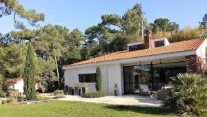 a house with glass doors and a yard at A l'Ombre des Pins in La Baule