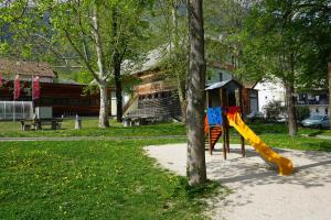 a playground with a slide next to a tree at Krona Apartments in Bovec