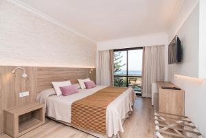 a hotel room with a bed and a balcony at Hotel Na Taconera in Cala Ratjada