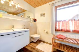 a bathroom with a toilet and a sink and a window at Appartement Walserstuba by A-Appartments in Brand