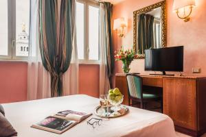 a hotel room with a desk and a television at Raeli Hotel Siracusa in Rome