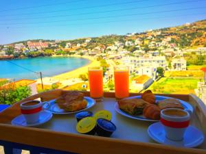 a tray of food on a table with a view of a beach at Erato Apartments in Batsi