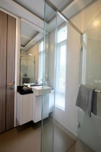 a bathroom with a sink and a glass shower at Villa Arusha Jogja in Sleman