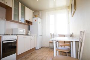 a kitchen with a table and a white refrigerator at ApartLux Sokolnicheskaya Superior in Moscow