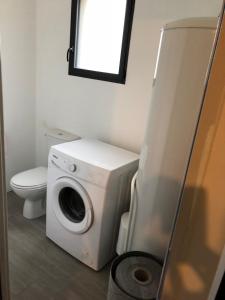 y baño con aseo y lavadora y secadora. en Gîte Le Clos de la Bertinière, en Bosgouet