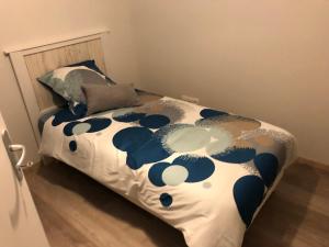 1 dormitorio con 1 cama con edredón azul y blanco en Le Clos de la Bertinière, en Bosgouet