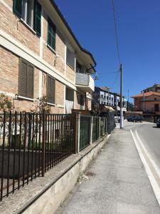 an empty street next to a building with a fence at Itaka in LʼAquila