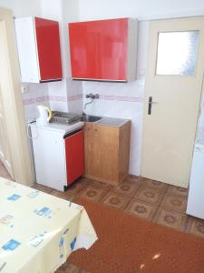 a kitchen with red and white cabinets and a sink at chalupy Šuňava in Vyšnie Šuňava