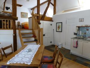 eine Küche und ein Esszimmer mit einem Holztisch und einer Treppe in der Unterkunft Feriengaleriewohnung Im Denkmal Stilvoll-Komfortabel Baubiologisch in Erlenbach