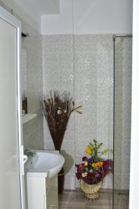 uma casa de banho com um lavatório, um WC e um vaso de flores em Cazare Fundeni em Bucareste