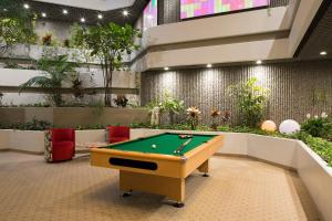 uma mesa de bilhar num quarto com plantas em Parkhotel CUP VITALIS em Bad Kissingen