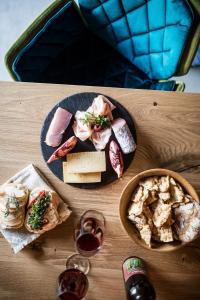stół z dwoma talerzami jedzenia i dwoma kieliszkami wina w obiekcie Weingut Weidlhof - Suite & Breakfast - Vacation for wine lovers w mieście Caldaro