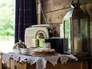 a table with a cake and a sewing machine at The Old Apple Shed cosy heated cottage in a meadow close to the charming village of Bethersden in Ashford